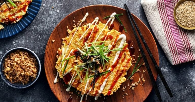 Ízletes okonomiyaki palacsinta, majonézzel és zöldhagymával díszítve.