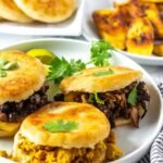 Három arepa különböző töltelékekkel: fekete bab, húsgulyás és tojásos. Korianderrel díszítve.